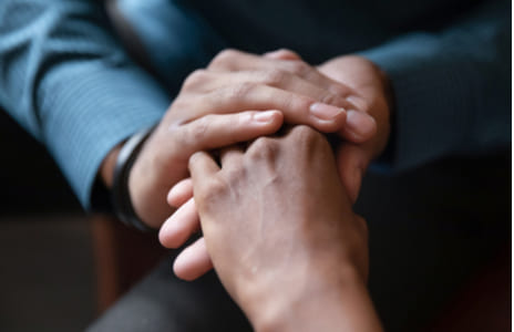 Врач держит пациента за руку